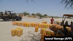 Des évacués des îles nigériennes du lac Tchad attendent de recevoir de la nourriture du Comité international de la Croix-Rouge, le 25 mai 2015 à Bosso. 