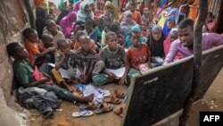 L'étudiant universitaire Yahye Mohamed donne une leçon aux enfants déplacés en tant que professeur bénévole dans une école de fortune au camp de Badbado à Mogadiscio, en Somalie, le 25 juin 2018.