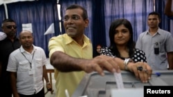 FILE - Maldivian Democratic Party (MDP) presidential candidate Mohamed Nasheed, who was ousted as president in 2012, center, casts his vote at a polling station during the presidential elections in Male, Nov. 9, 2013. 