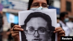 Un manifestante porta un cartel con el rostro de Juan Francisco Sandoval durante una protesta el 24 de julio de 2021, en Ciudad de Guatemala.