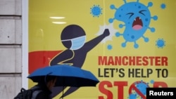 A man walks past a poster amid the outbreak of the coronavirus disease, in Manchester, Britain, Oct. 21, 2020. (Reuters)