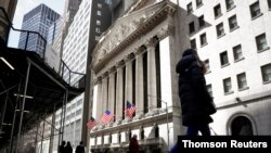 FILE PHOTO: People are seen on Wall St. outside the NYSE in New York