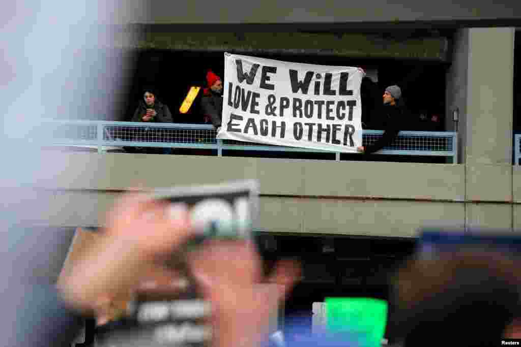 Spanduk yang dipasang demonstran dalam protes melawan larangan imigrasi Presiden AS Donald Trump, di luar Terminal 4 Bandar Udara Internasional John F. Kennedy di Queens, New York (28/1). (Reuters/Andrew Kelly)