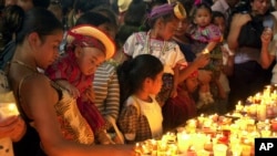 ARCHIVO - Fieles encienden velas mientras visitan el Santuario de la Virgen de Guadalupe para celebrar su día en la Ciudad de Guatemala el jueves 12 de diciembre de 2002.