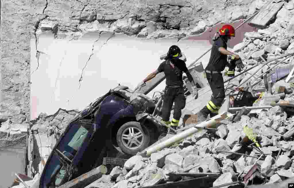 Rescuers make their way through destroyed houses following Wednesday's earthquake in Pescara Del Tronto, Italy, Aug. 25, 2016.