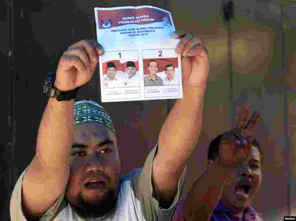 An election official holds up a ballot paper during the counting of votes cast in the country's presidential election, in Makassar, South Sulawesi, Indonesia, July 9, 2014.