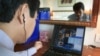 FILE - Tran Huynh Duy Thuc, founder of a Vietnamese Internet provider, makes a telephone call via the Internet in his office in Hanoi, July 3, 2003.Ho Chi Minh City is quickly becoming a destination for “tech nomads” – online entrepreneurs looking to take