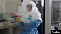 A laboratory specialist examines specimens of the Ebola virus at the Uganda virus research centre in Entebbe, 40km (25 miles) south from capital Kampala, May 17, 2011. 