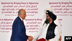 Tinchlik bo'yicha AQSh elchisi Zalmay Xalilzod (chapda) Tolibon yetakchilaridan biri Mulla Abdul G'ani Barodar bilan, Doxa, Qatar, 2020-yil, 29-fevral