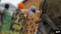 Des femmes et un homme armé à Aveba, dans le sud de l’Ituri, RDC, 30 juillet 2006.