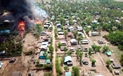 FILE - A fire burns in the predominantly ethnic Rakhine village of Let Kar in Rakhine State's Mrauk-U township, western Myanmar, May 16, 2020.