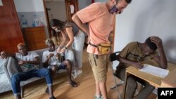 Les migrants nouvellement arrivés sont assis avec les employés de Quorum Social 77 dans l'un des centres d'accueil de l'association à Gran Canaria, dans les îles Canaries espagnoles, le 15 septembre 2020. (Photo: DESIREE MARTIN / AFP)