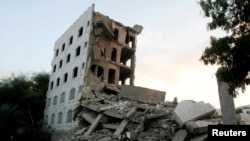 Seorang pria berjalan di puing-puing bangunan yang runtuh setelah terkena serangan udara yang dipimpin Saudi di kota barat daya Taiz, Yaman, 29 November 2016. (Foto: dok).
