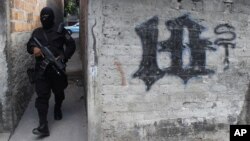 Un miembro de la Policía Nacional Civil de El Salvador camina por uno de los barrios controlados por la pandilla Barrio 18. Contra esta, junto con la Mara Salvatrucha y otras estructuras, el presidente Bukele autorizó usar la fuerza letal. 