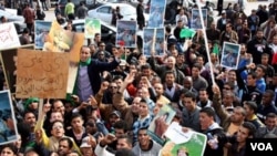 Para demonstran meneriakkan slogan dan membawa poster dukungan bagi Moammar Gadhafi dalam unjuk rasa di Tripoli, Rabu (16/2).