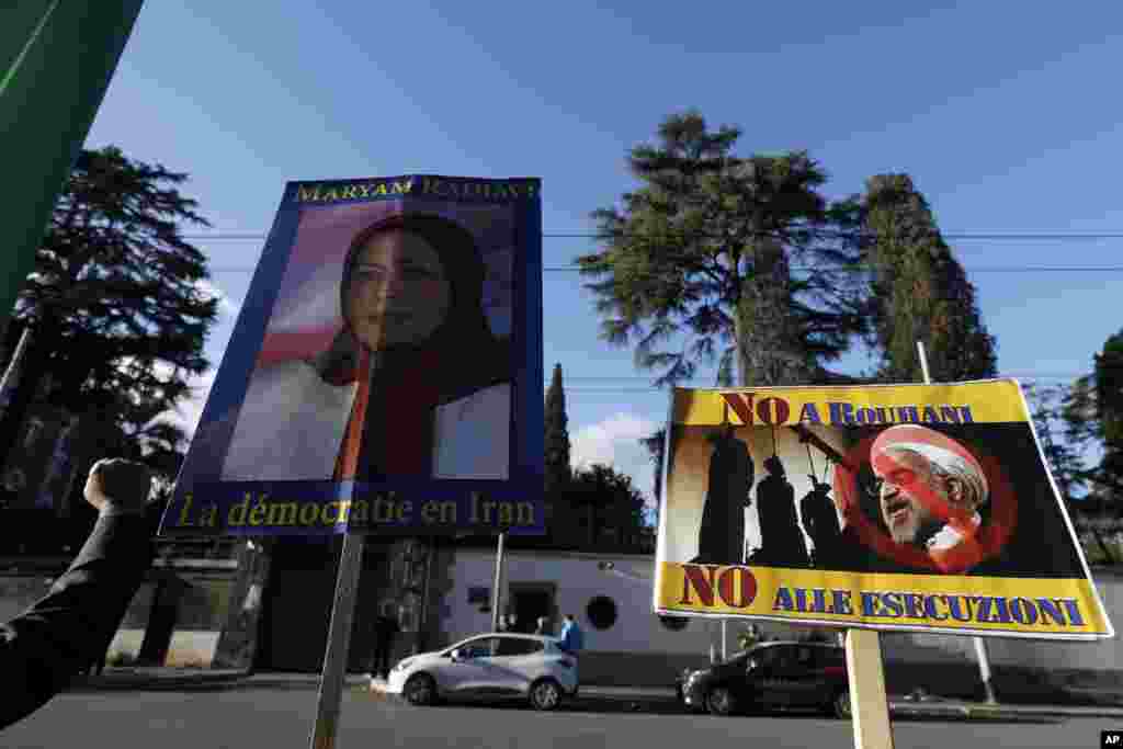 Masu zanga zanga dauke da tutar Maryam Rajavi madugun 'yan adawar kasar Iran, National Resistance Council, da kwalaye da aka yi rubutu kansu da harshen Faransanci suna cewa "Dimokradiya a Iran". Ta hannun hagu kuma akwai hoton shugaban Iran Hassan, Janairu 02, 2018