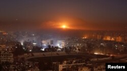 FILE - Smoke and flames rise after air strikes on rebel-controlled besieged area of Aleppo, as seen from a government-held side, in Syria, Dec. 11, 2016.