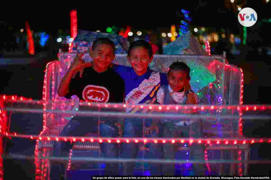 Un grupo de niños posan para una foto, en uno de los trineos iluminados por Navidad en la ciudad de Granada, Nicaragua. Foto Donaldo Hernández/VOA.