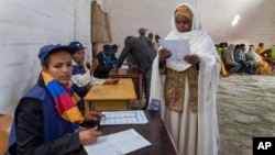 A woman looks at the election paper before voting in Ethiopia's general election, in Addis Ababa, Ethiopia, May 24, 2015. 