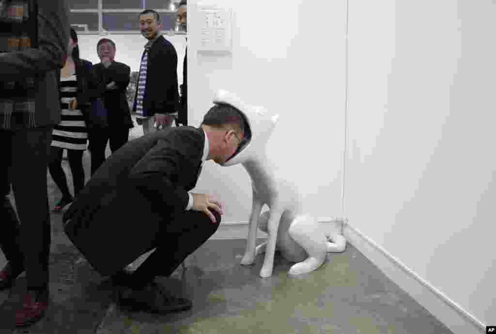 A man looks at an art installation "Face To Face" created by Taiwan artist Peng Hung-chih during the VIP preview of the art fair "Art Basel" in Hong Kong, March 22, 2016.