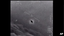 En la imagen del video proporcionado por el Departamento de Defensa etiquetado como Gimbal, de 2015, se ve un objeto inexplicable en el centro mientras se rastrea mientras se eleva a lo largo de las nubes, viajando contra el viento.