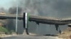 An image grab taken from a video released by the United Nations Supervision Mission in Syria shows smoke rising following shelling from the central flashpoint city of Homs on June 11, 2012. 