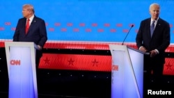 Kandidat demokrata za predsjednika SAD-a Joe Biden i republikanski predsjednički kandidat i bivši američki predsjednik Donald Trump okreću pogled jedan od drugog tokom svoje debate u Atlanti, Džordžija, SAD, 27. juna 2024. REUTERS/Brian Snyder