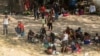 Migrantes solicitantes de asilo descansan a la sombra cerca del Puente Internacional entre México y Estados Unidos, donde los migrantes solicitantes de asilo esperan ser procesados en Del Rio, Texas, EE. UU., el 15 de septiembre de 2021.