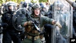 Police begin to clear demonstrators gathered as they protest the death of George Floyd, June 1, 2020, near the White House in Washington.