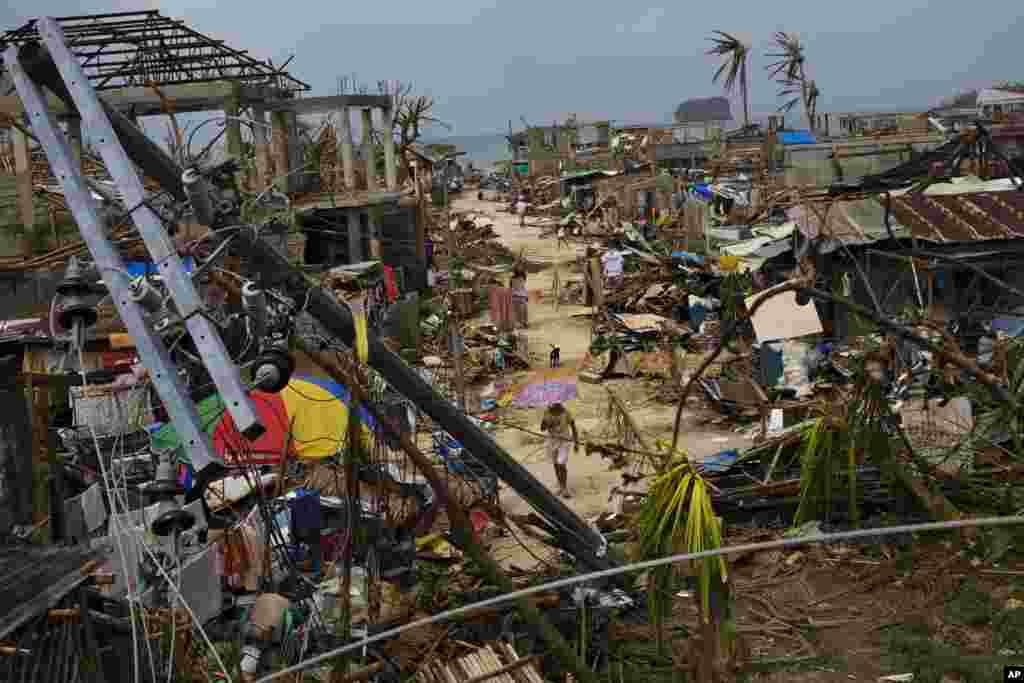 Typhoon Haiyan survivors walk through ruins in the village of Maraboth, Philippines, Nov. 14, 2013. 