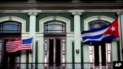 A Jan. 19, 2015 photo shows the Cuban and US flags waving from the balcony of the Hotel Saratoga in Havana.