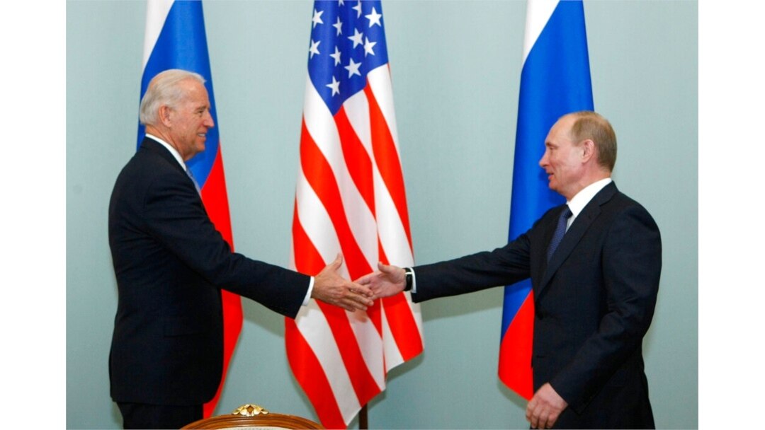FILE - Joe Biden (left), then vice president of the United States, shakes hands with Russian Prime Minister Vladimir Putin in Moscow, March 10, 2011.