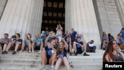 Jóvenes de secundaria visitan el Monumento a Lincoln en Washington el 18 de junio de 2021 tras el levantamiento de restricciones por COVID-19.