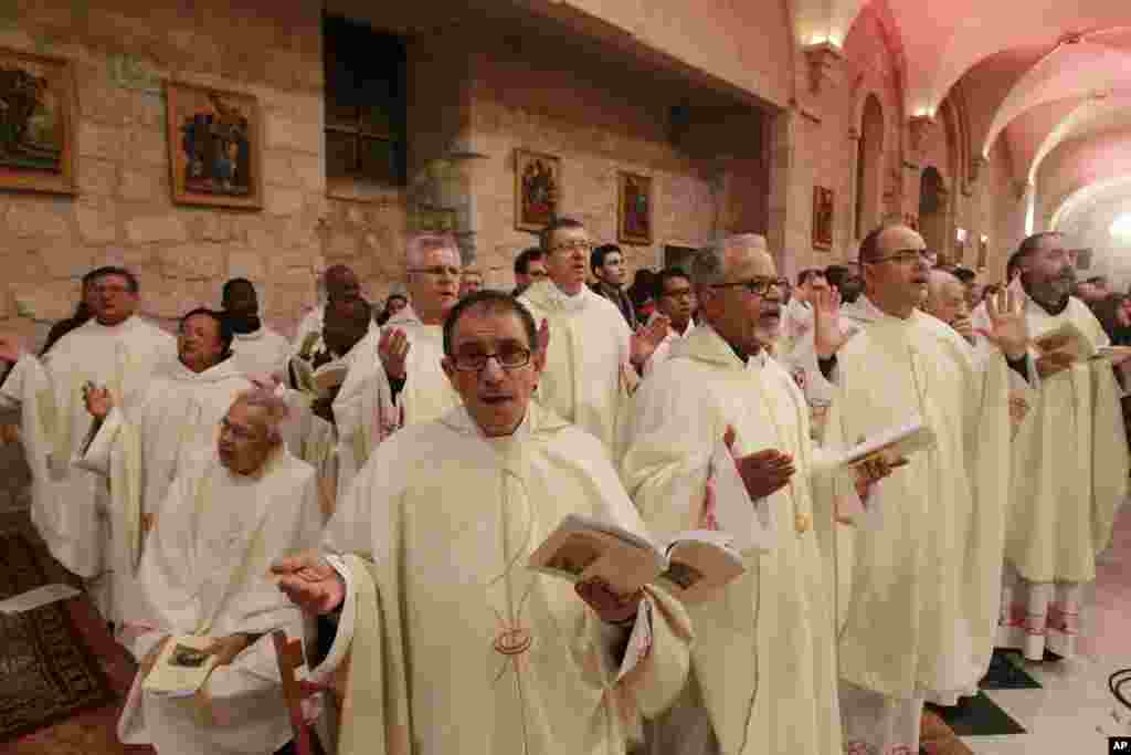 Latin clergies pray as they walk to the Grotto at the end of the Christmas Midnight Mass at Saint Catherine's Church where Christians believe the Virgin Mary gave birth to Jesus Christ, in the adjacent Church of the Nativity in Bethlehem, West Bank, Dec. 25, 2016.