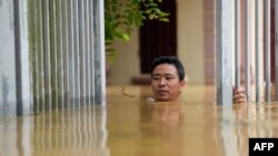បុរសម្នាក់ដើរកាត់ទឹកជំនន់នៅក្រៅផ្ទះរបស់ខ្លួនក្នុងខេត្ត Thai Nguyen កាលពីថ្ងៃទី១០ កញ្ញា ឆ្នាំ២០២៤។