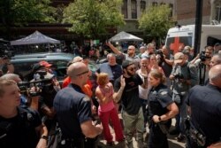 Police separate supporters of President Donald Trump from those who are opposed to the president during an argument near the site of a mass shooting in Dayton, Ohio, Aug. 7, 2019.
