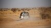 FILE - Migrants crossing the Sahara desert into Libya ride on the back of a pickup truck outside Agadez, Niger, May 9, 2016. The International Organization for Migration said on March 22, 2024, that the bodies of at least 65 migrants were discovered in a mass grave in Libya.
