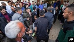 Palestinos llevan a una persona herida tras un ataque aéreo israelí cerca del hospital de Al Aqsa en Deir al Balah, en la Franja de Gaza, el domingo 31 de marzo de 2024.