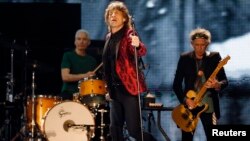 Mick Jagger (C), Charlie Watts (L) and Keith Richards of the Rolling Stones perform during a concert in Abu Dhabi, Feb. 21, 2014.