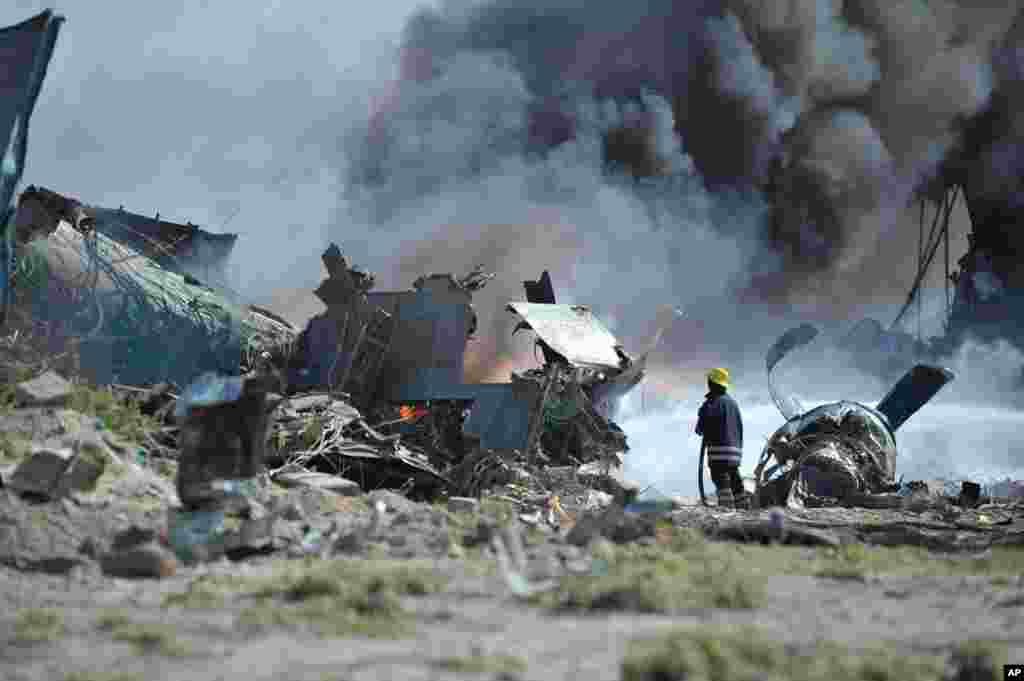 African Union Mission in Somalia firefighters attempt to extinguish the fire at the site of an plane crash in Mogadishu, Somalia, August 9, 2013. (AMISOM)