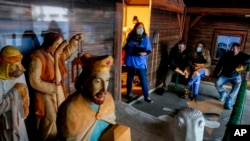 Seorang petugas medis dan beberapa warga tampak menunggu di pasar natal di Offenbach, Jerman, pada 24 November 2021, untuk mendapatkan vaksin COVID-19. (Foto: AP/Michael Probst)