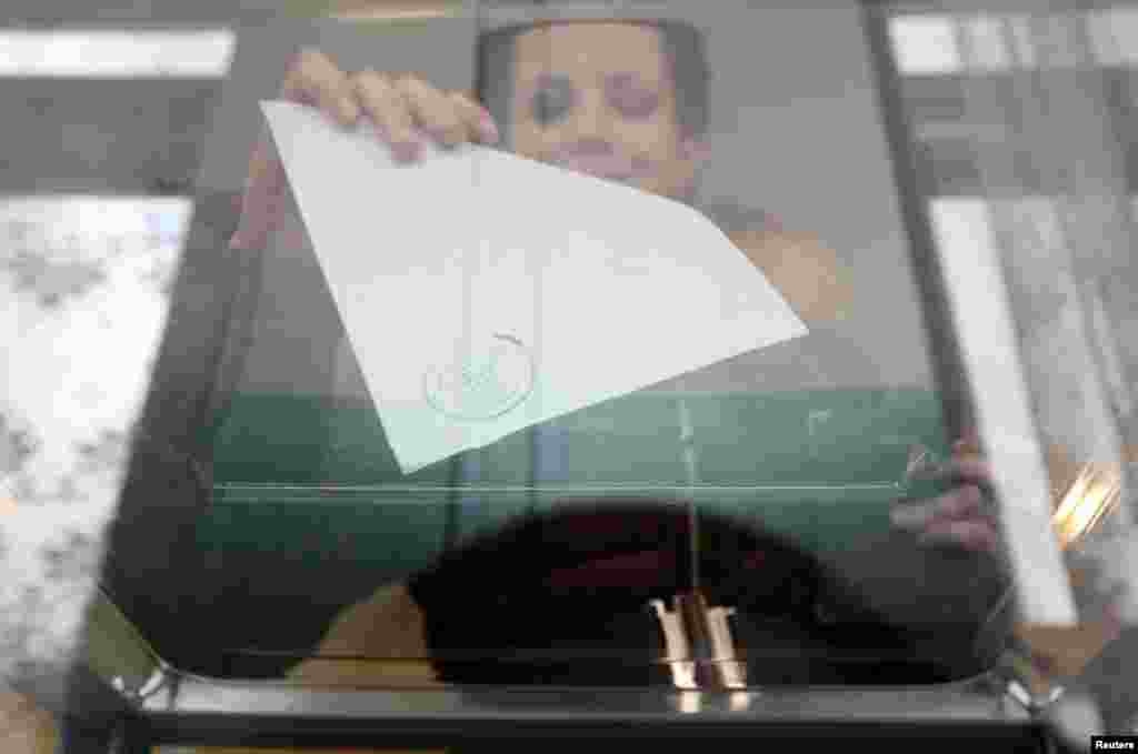 Seorang perempuan memberikan suaranya dalam referendum status kawasan Krimea, Ukraina di tempat pemungutan suara di Bakhchisaray, Krimea, Ukraina, 16 Maret 2014.