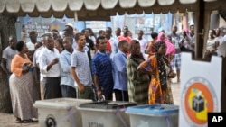 Watanzania wakiwa kwenye foleni kwenye kituo kimoja cha kupigia kura mjini Dar es Salaam, Okt. 25, 2015. 