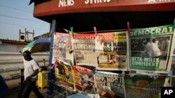Un homme passe devant un kiosque à journaux près de la station de Neoplan à Accra, au Ghana, 8 décembre 2008. 