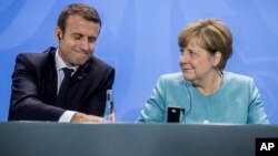 Presiden Prancis Emmanuel Macron (kiri) dan Kanselir Jerman Angela Merkel (kanan) menghadiri konferensi pers seusai pertemuan menjelang KTT G-20 di Berlin, Jerman, Kamis, 29 Juni 2017. (Michael Kappeler / dpa via AP)