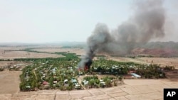 In this photo released by the Myanmar Army, a fire burns May 16, 2020, in the predominantly ethnic Rakhine village of Let Kar in Rakhine State's Mrauk-U township, western Myanmar.