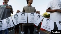 Para demonstran membawa gambar-gambar 43 mahasiswa Meksiko yang hilang dalam unjuk rasa di kota Guadalajara (8/10).