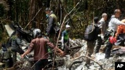 Petugas mengumpulkan puing-puing pesawat yang jatuh di Pegunungan Bintang, Papua. (Foto: Dok)