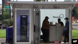Government employees open the customer service area of a Chivo digital wallet machine, which exchanges cash for Bitcoin cryptocurrency, at Las Americas Square in San Salvador, El Salvador, Tuesday, Sept. 7, 2021.