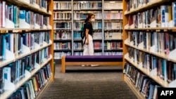 A women looks at books in a public library in Hong Kong on July 4, 2020. Books written by prominent Hong Kong democracy activists have started to disappear from the city's libraries, online records show.